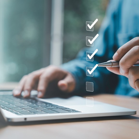 Person arbeitet Checkliste am Laptop ab