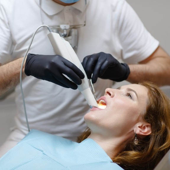 Patientin wird mit Intraoralscanner behandelt